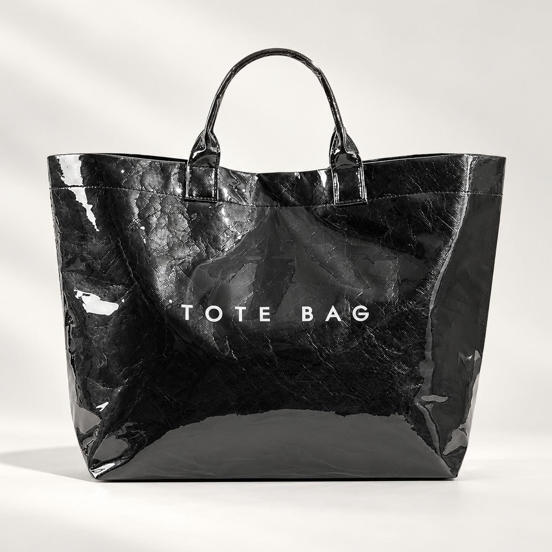 Famous Tote in Black, large waterproof kraft paper tote with glossy PVC shell and Velcro closure, 13.2 x 5.7 x 11.8 in