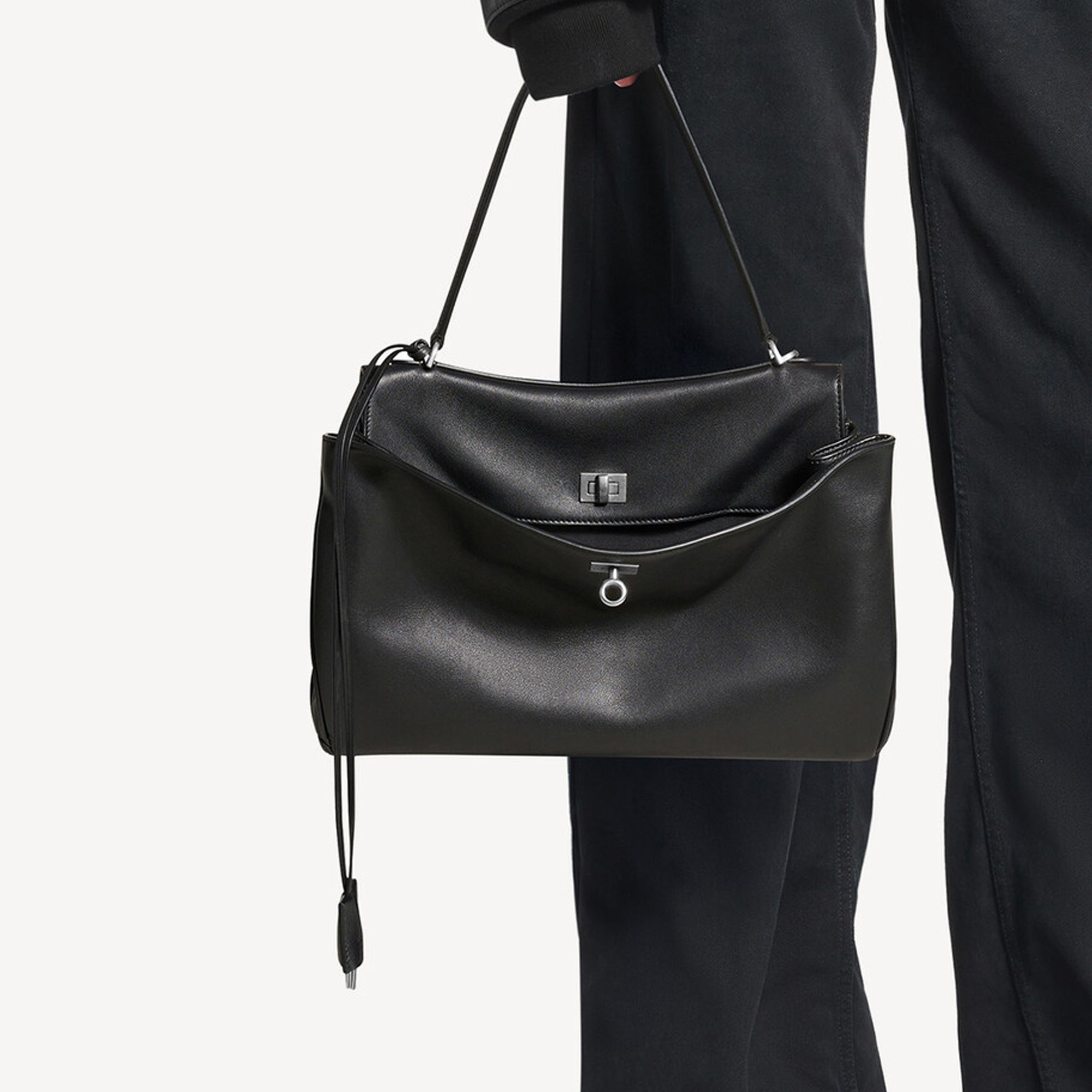 black slouchy medium tote bag with polished silver hardware and a relaxed rectangular shape.