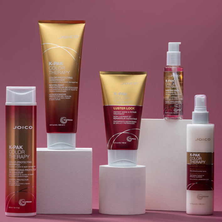 Collection of Joico hair care products on a pink background