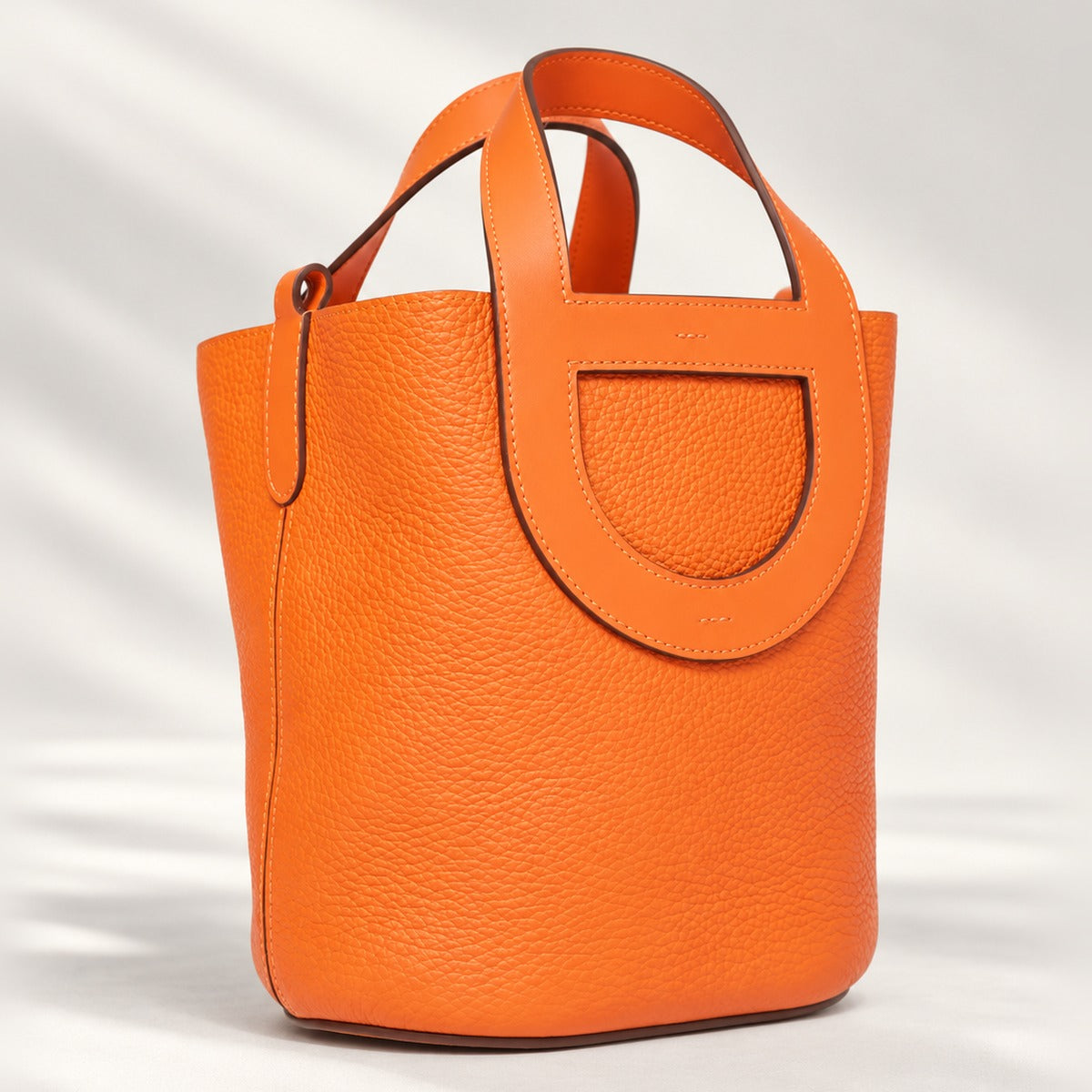 Compact Loop Leather Bucket Bag in Orange, smooth leather with loop handles, silver strap detail and two side pockets