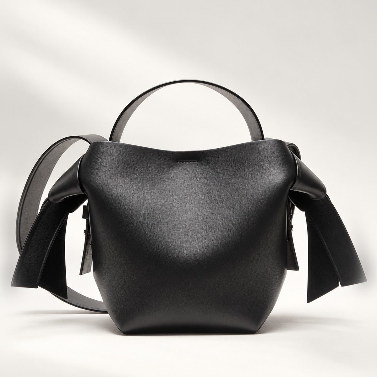 Mini Knot Leather Shoulder Bag in Black with silver hardware, twisted knot sides, top handle and detachable crossbody strap
